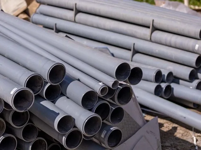 Szürke PVC csövek kötegelve egy építési területen